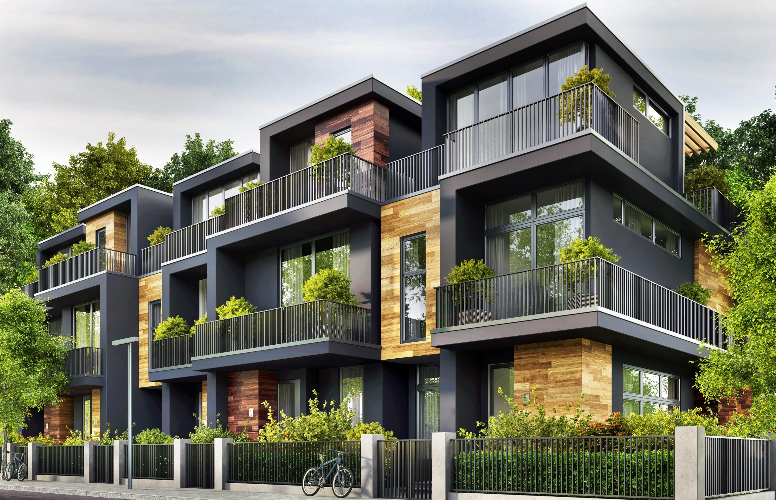 Modern looking condo complex with lots of windows and greenery.